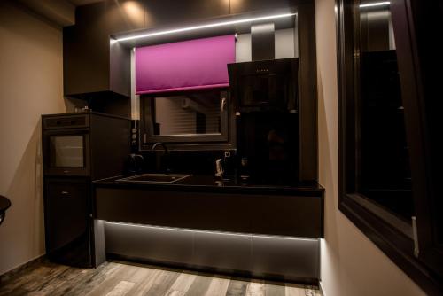a black kitchen with a sink and a window at Paraiso Azul Villas in Áyios Dhimítrios