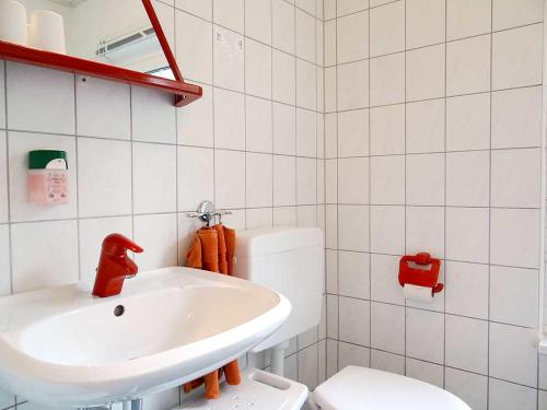 a white bathroom with a sink and a toilet at Strandhotel Villa Louisa & Appartementhäuser Villa Josephine und Villa Christine in Juliusruh