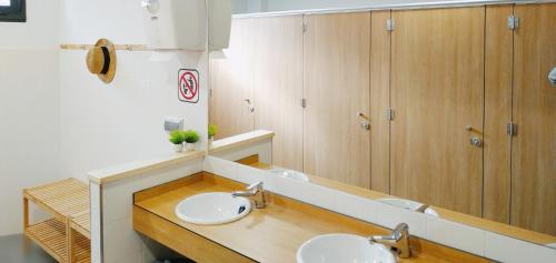 a bathroom with two sinks and a large mirror at Albergue Nacama hostel Pontevedra in Pontevedra