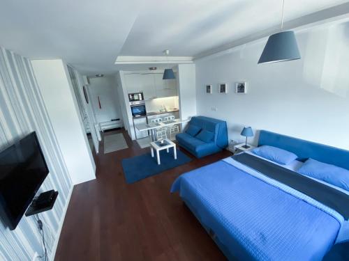 a bedroom with a blue bed and a blue chair at Apartment Azzurro lux in Novi Beograd