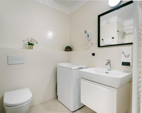 Jarila Boutique Apartment في براتيسلافا: حمام أبيض مع حوض ومرحاض