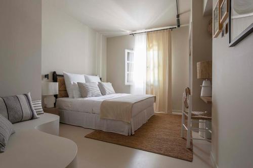 a bedroom with a white bed and white walls at Yayaki Spetses in Spetses