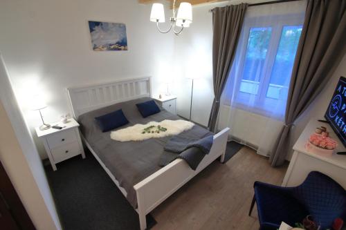 um pequeno quarto com uma cama e uma janela em A tornácos panzió em Kéthely
