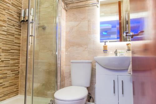a bathroom with a toilet and a sink and a shower at Meridian Serviced Apartments in Bradford