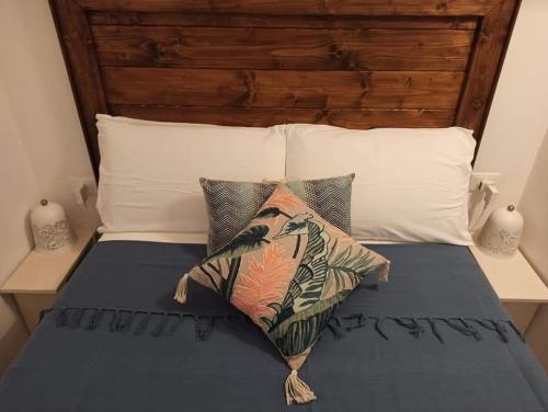 Bett mit einem Kopfteil aus Holz und Kissen darauf in der Unterkunft Casetta Elilù in Ostuni