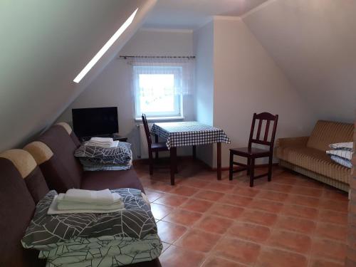 een woonkamer met een bank, een tafel en stoelen bij U Ewy i Grzesia in Krzeszna