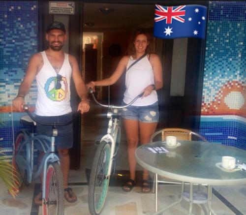 a man and a woman standing with bikes and a table at Santa Sophia Del Mar B&B hotel in Santa Marta