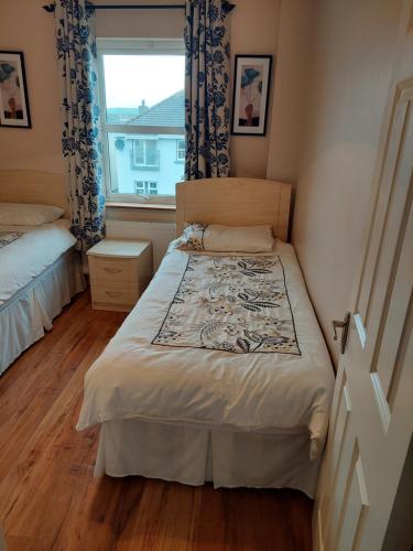 a small bedroom with a bed and a window at Lios na Mara Lahinch in Lahinch