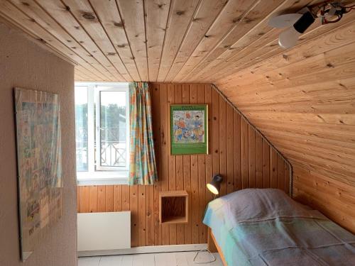 a bedroom with a wooden ceiling with a bed in it at Mandøgården in Ribe