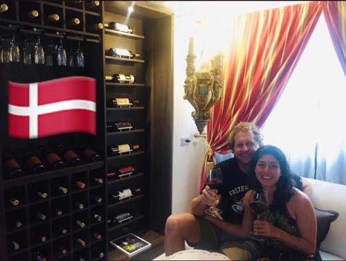 a man and woman sitting on a couch holding wine glasses at Santa Sophia Del Mar B&B hotel in Santa Marta