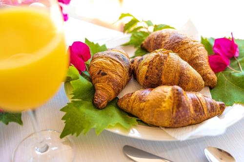a plate of croissants and a glass of orange juice at Hotel Villa Cute - HVC in Lipari