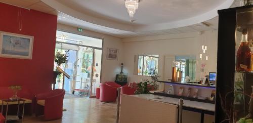 a room with red chairs and a hair salon at Logis Hôtel & Restaurant Le Fleurance in Fleurance