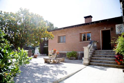a brick house with a staircase leading to the door at Casa de campo en pelayos in Pelayos de la Presa