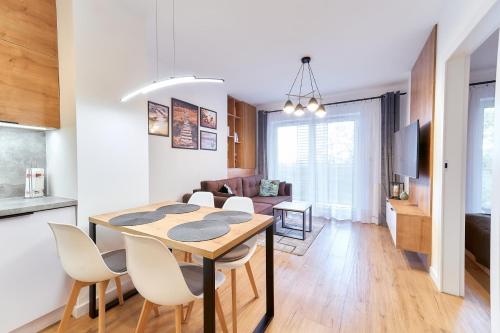 een eetkamer en een woonkamer met een tafel en stoelen bij LAGUNA Apartament Polanica Residence 45 in Polanica-Zdrój