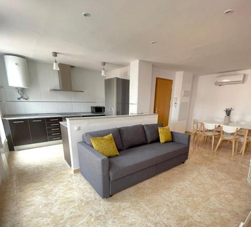a living room with a couch and a kitchen at UIM Mediterraneo Poeta 4 Wifi in Puerto de Sagunto