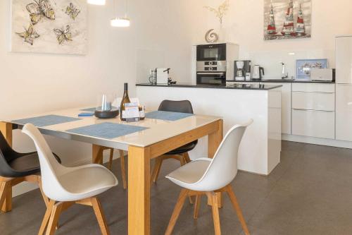 cocina con mesa de madera con sillas y barra en First Meereskristall, en Ostseebad Sellin