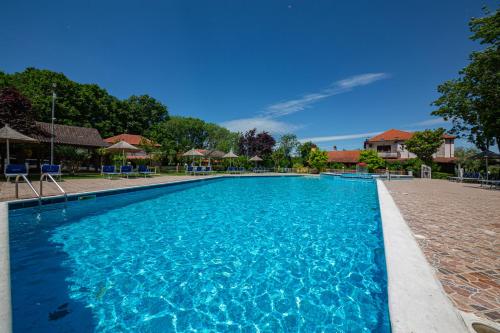 a large swimming pool with blue water at Sebastiano Resort in Lezhë