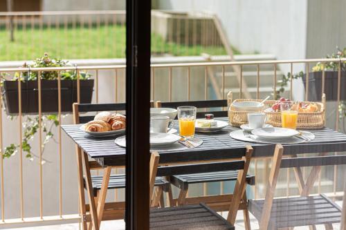 a table with food and drinks on a balcony at Feel Porto Corporate Housing Campanhã in Porto