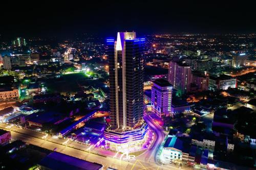 a city lit up at night with a tall building at Aleeya Suite @ Troika Residence in Kota Bharu