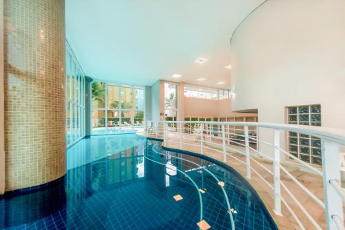 una piscina en un edificio con balcón en Pool Ilha da Madeira Resort, en Riviera de São Lourenço