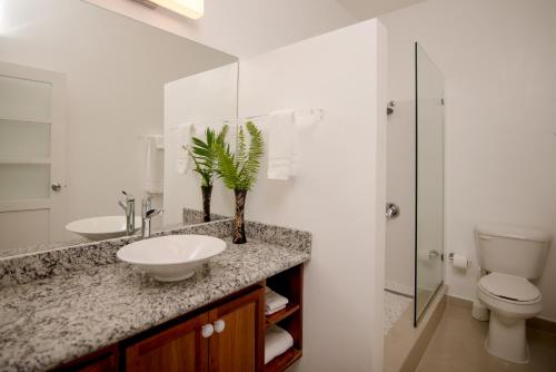 a white bathroom with a sink and a toilet at Whispering Seas Oceanfront Suite in Ocho Rios