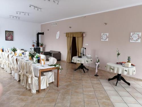 a room with white tables and white chairs in it at Głębia in Dąbrówno