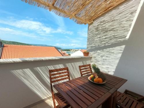 a table and chairs on a balcony with a bowl of fruit at Gavan Apartment in Cres