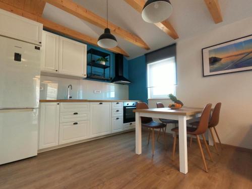 a kitchen with a table and chairs and a refrigerator at Gavan Apartment in Cres