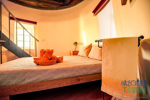 a bedroom with a bed with a stuffed animal on it at Boina de Vento in Santa Cruz da Graciosa