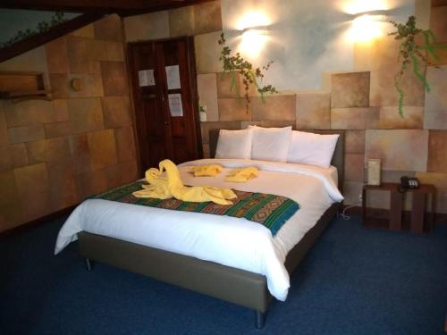 a bedroom with a large bed with towels on it at Hotel Boutique Spa Villa de Sant in Quito