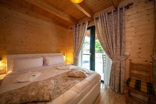 a bed in a wooden room with a window at Sebastiano Resort in Lezhë
