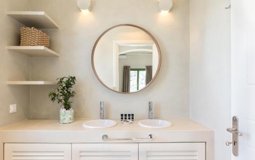 a bathroom with two sinks and a mirror at Casa Di Fiori Andros Suites in Andros