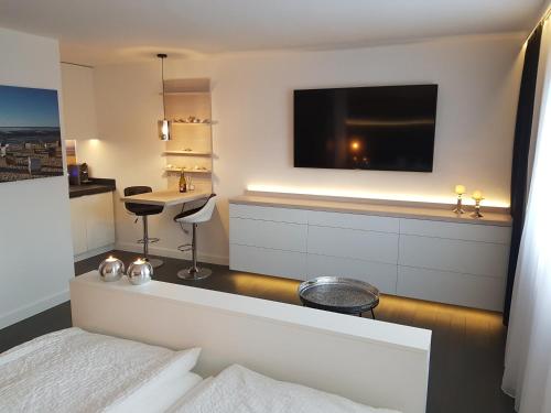 Habitación de hotel con cama y TV en la pared en kleine Düne en Cuxhaven