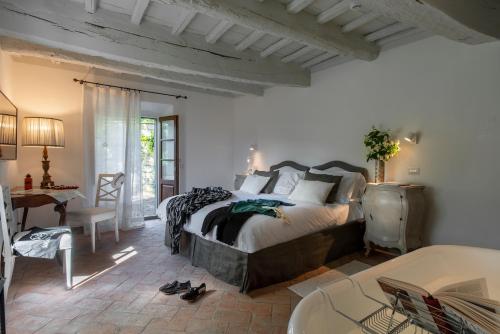 a bedroom with a large bed in a room with a table at Castello di Volpaia in Radda in Chianti