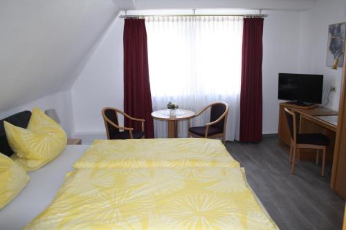 a bedroom with a bed and a table and a window at Pension / Ferienwohnung Allebrodt in Lennestadt