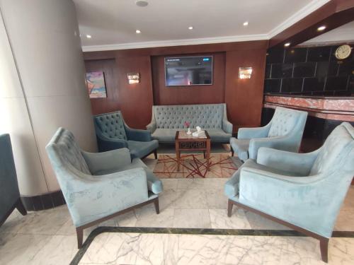 a waiting room with blue chairs and a table at Jewel San Stefano Hotel in Alexandria