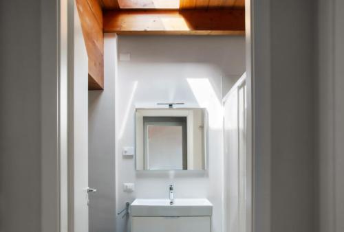 bagno con lavandino bianco e specchio di Residenza Puoti a Peschiera del Garda