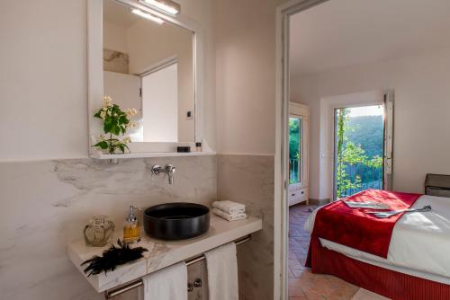 a bathroom with a sink and a bed and a mirror at Castello di Volpaia in Radda in Chianti