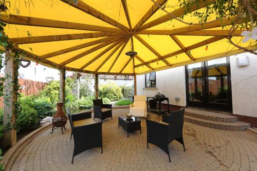 a large yellow umbrella sitting on a patio at Cloyfin B and B in Coleraine