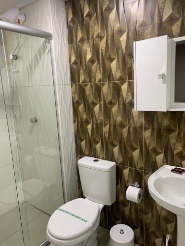 a bathroom with a toilet and a sink at Pousada Mercosul in Alegrete