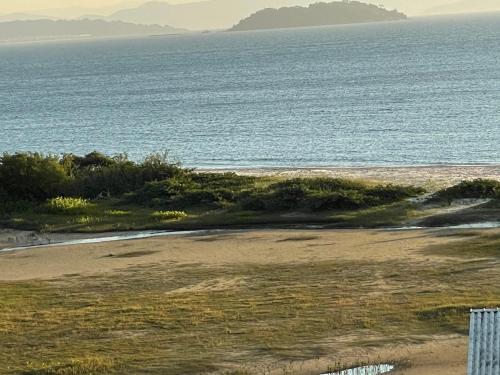 an empty beach with the ocean in the background at Apartamento Florianópolis ponta das canas in Florianópolis