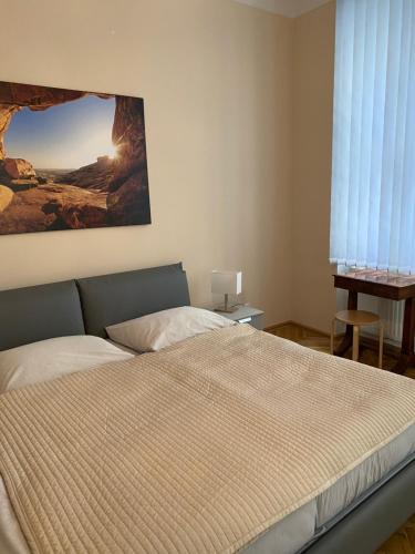 a bedroom with a bed and a painting on the wall at MQ Appartement in Vienna