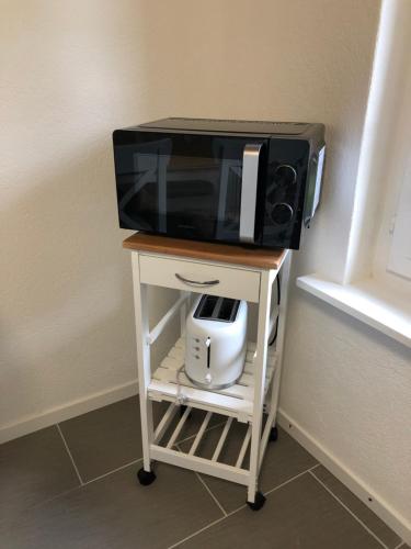 a microwave on a stand with a tv on it at Villa Matten in Matten