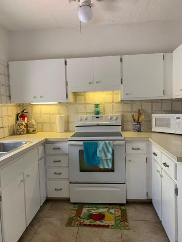 a kitchen with white cabinets and a white stove top oven at Sweet Serenity St Croix USVI in Christiansted