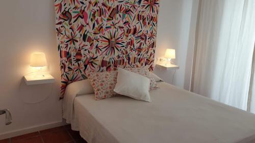 ネルハにあるPerfecto apartamento centricoのベッドルーム1室(白いベッド1台、ランプ2つ付)