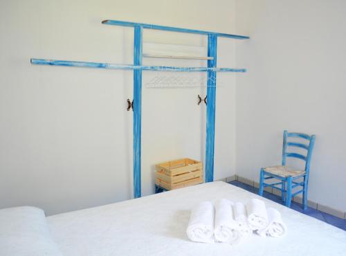a bedroom with a bed and a blue chair at Le case di Nina in Maratea