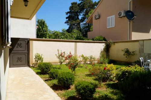 einen Garten vor einem Haus mit einem Zaun in der Unterkunft Veron Apartments in Kotor