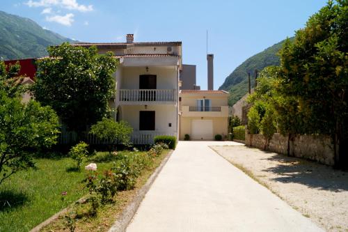 a white house with a mountain in the background at Veron Apartments in Kotor