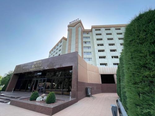 a hotel building with a large building at Rohat Hotel Chilonzor in Tashkent