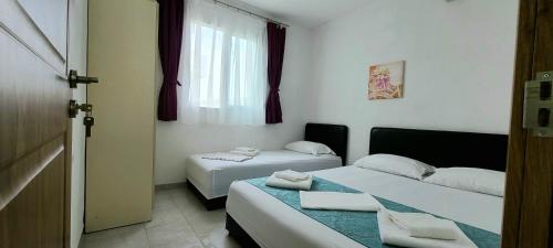 a hotel room with two beds and a window at Riviera Inn apartments in Ulcinj